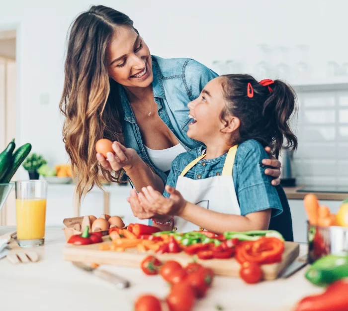Mother and daughter preparing fresh vegetables together in the kitchen, representing healthy living with Independa